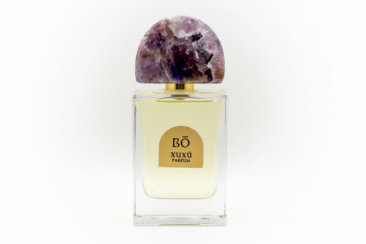 Perfume bottle with a decorative cap featuring amethyst stones on a white background